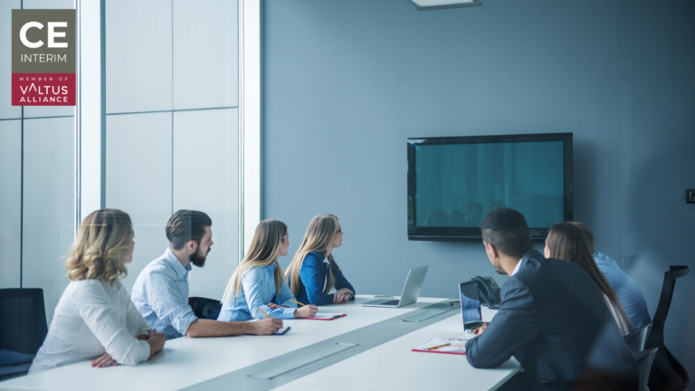 Executives in a boardroom looking at screen